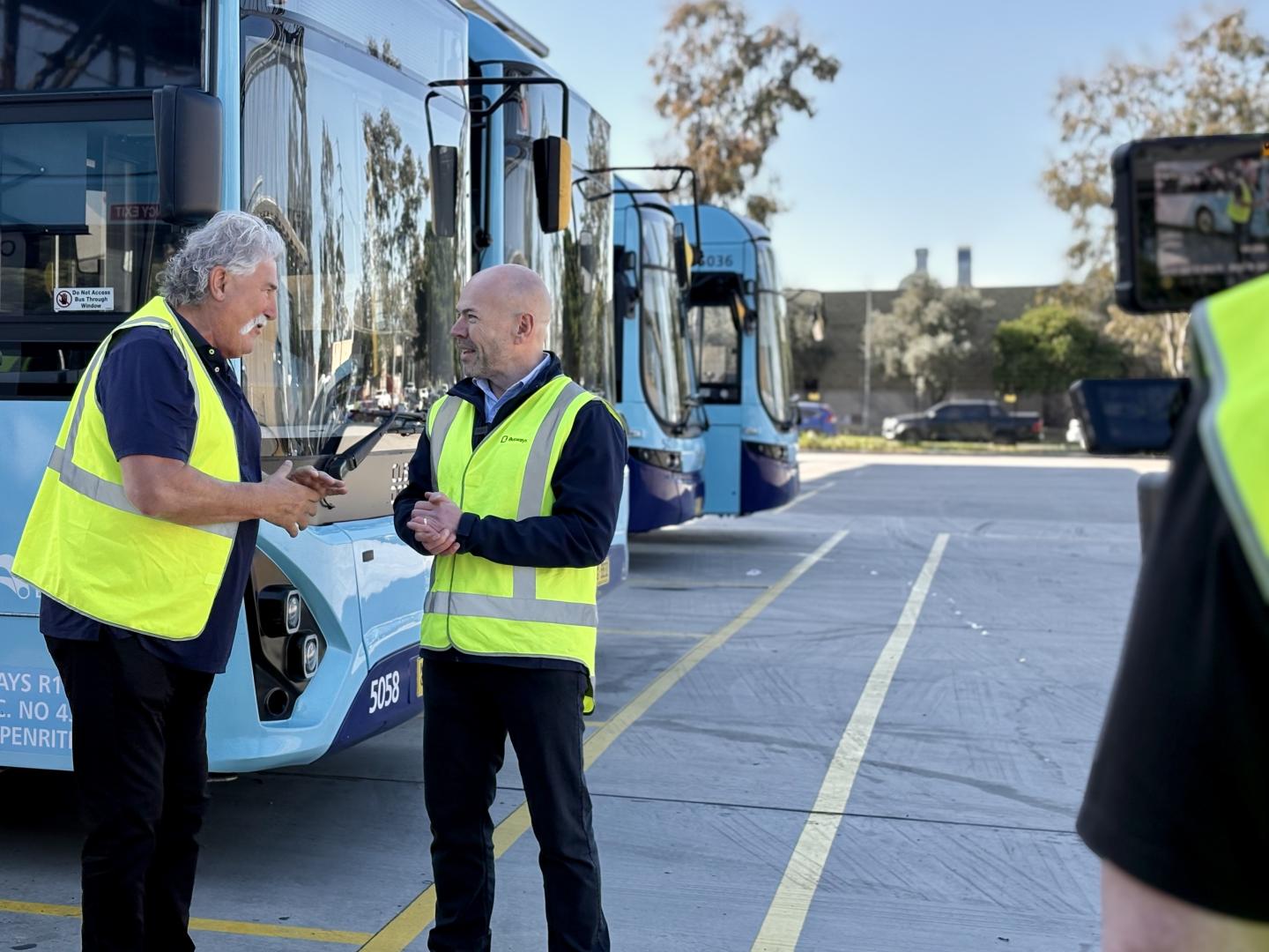Dipper and Will O'Neill standing in front of a blue bus being filmed