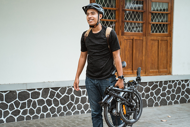 Cyclist walking with his foldable bike