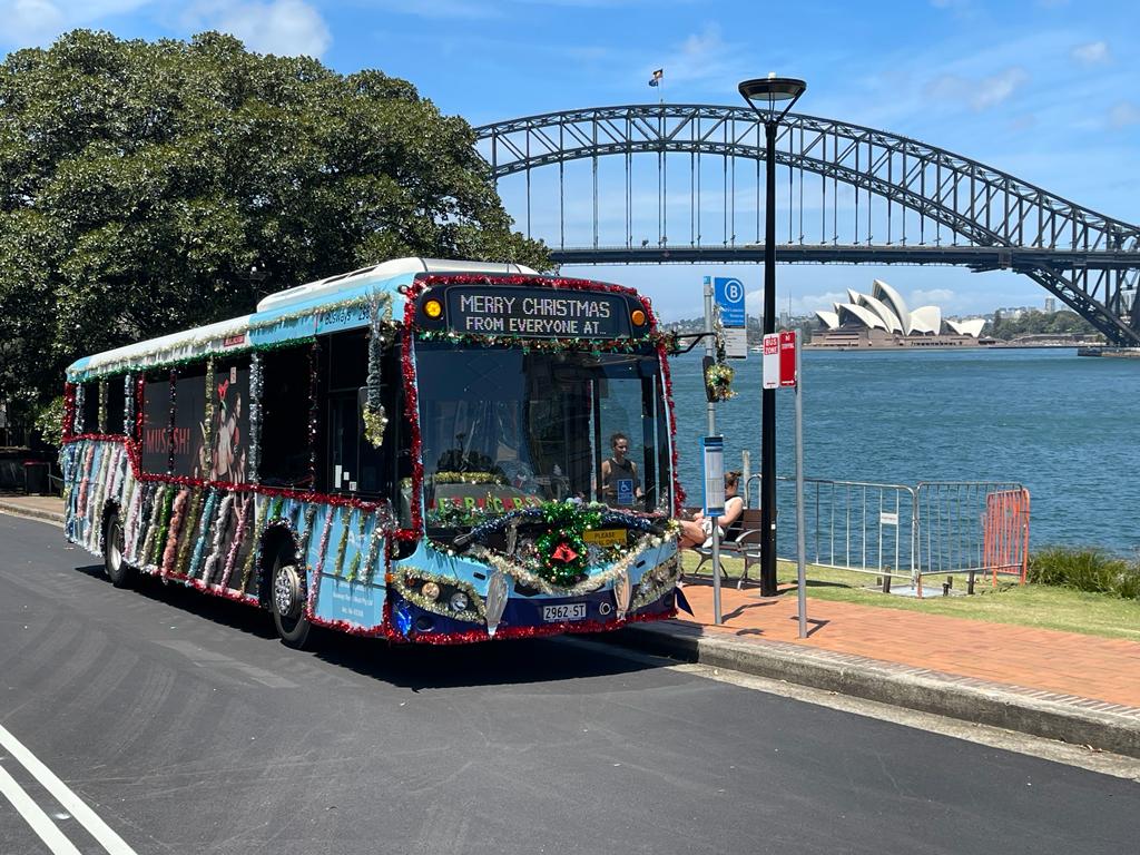 Christmas decoration on external bus with Sydney Harbour bridge in background