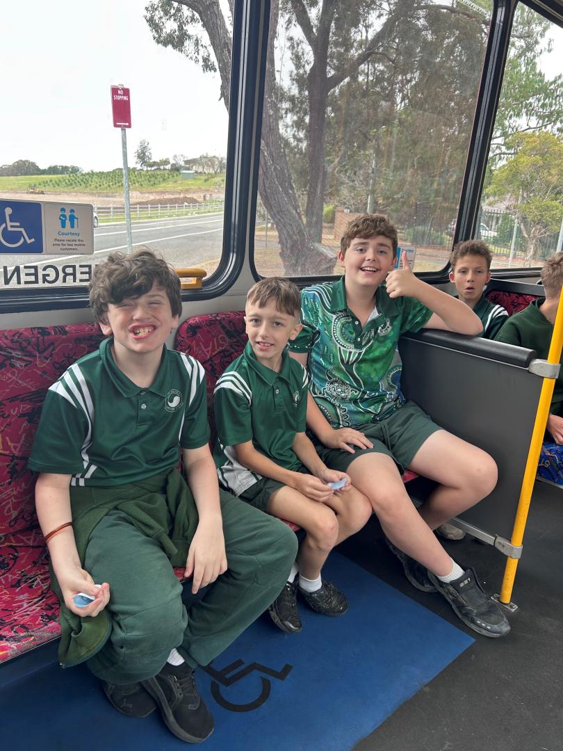 Students smiling while on the practical bus ride component of the bus education program