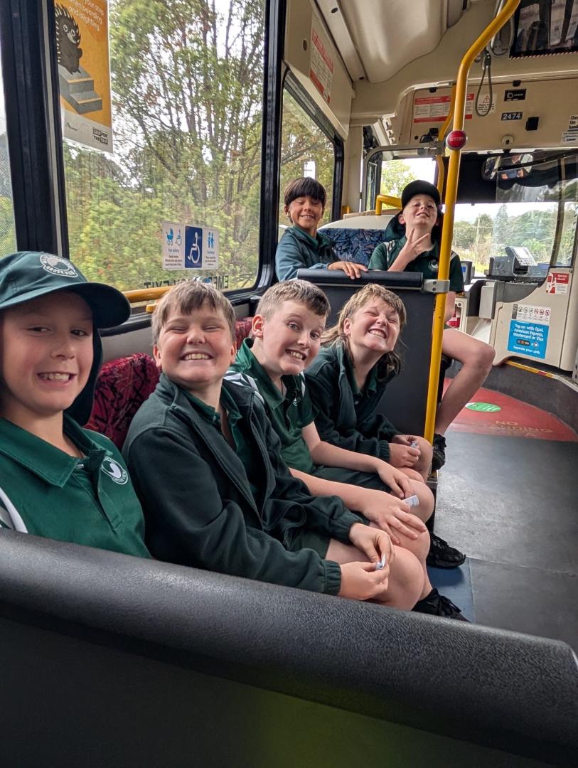 Students smiling while on the practical bus ride component of the bus education program